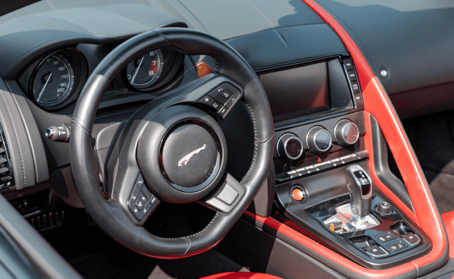 Interior design of a Jaguar F-TYPE S v8 AWD Convertible vehicle steering wheel and dashboard.