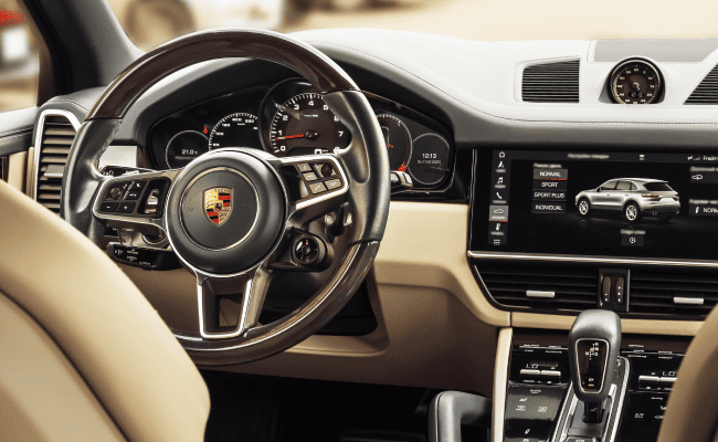 Porsche Cayenne luxury interior, steering wheel, and dashboard.