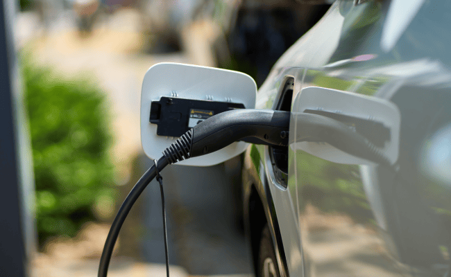 A white EV charging with the charging cable.