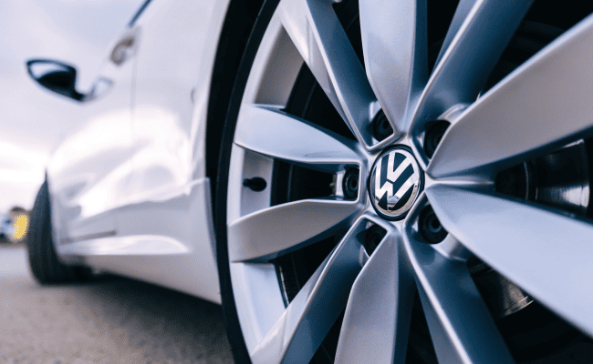 A close-up of a titanium disk on a white Volkswagen.